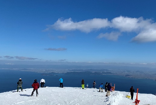 写真　真っ青な空、白銀のゲレンデ、眼下に広がる琵琶湖の眺望