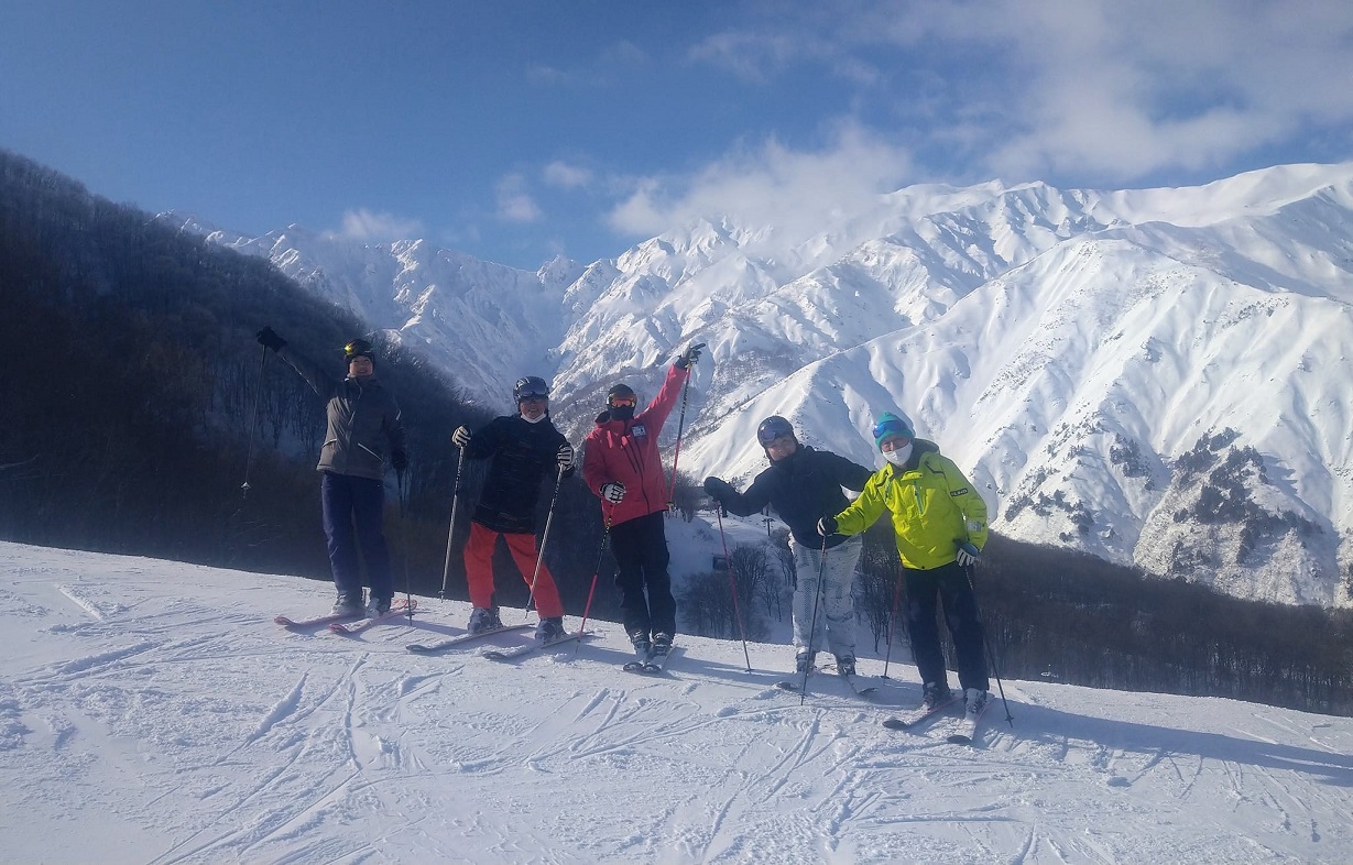 写真　白馬連峰を背景にスキーレッスン参加者整列
